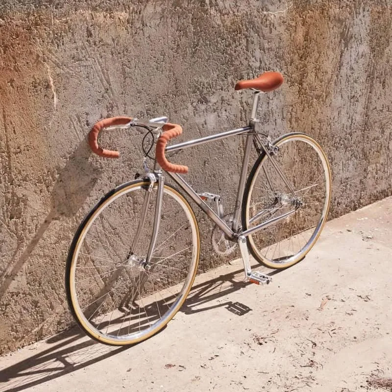 A Single Speed Cycles bike leaning against a wall